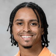 Bryan smiling at camera with orange shirt